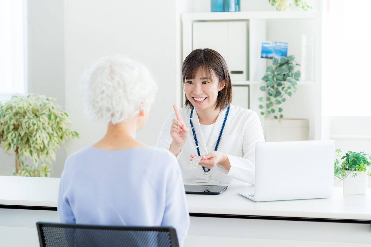 窓口で説明する医療従事者と来訪者のイメージ