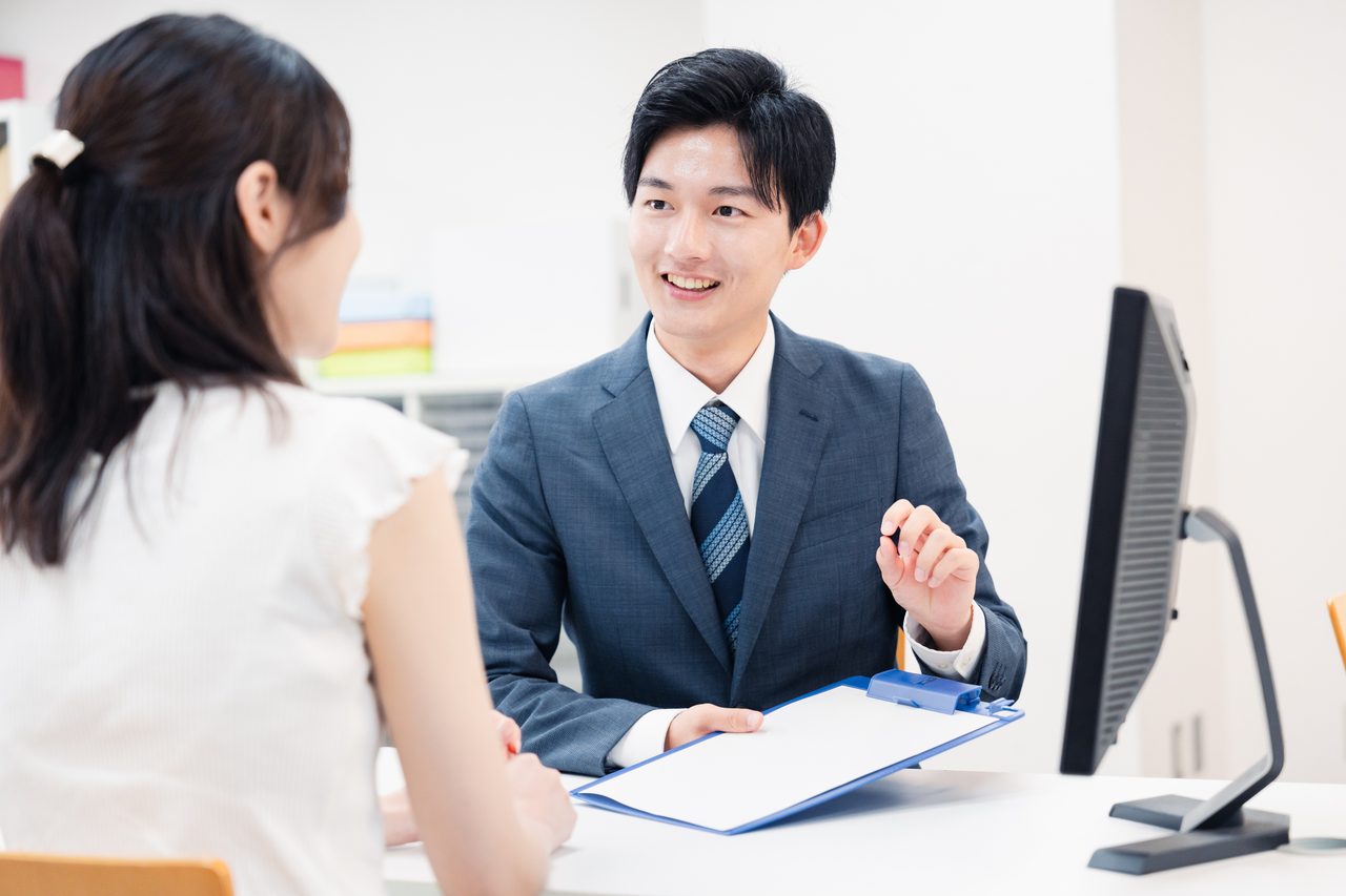 明るい相談窓口で担当者が来訪者に説明している様子（イメージ）